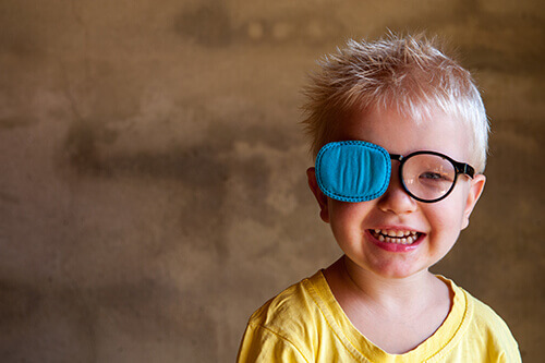Boy with amblyopia glasses and eye patch