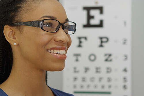 Young woman wearing glasses in front of an eye chart